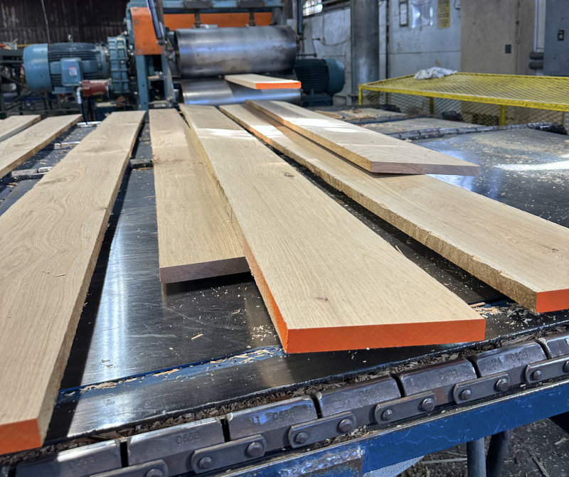 Lumber exiting the surface planning machine.