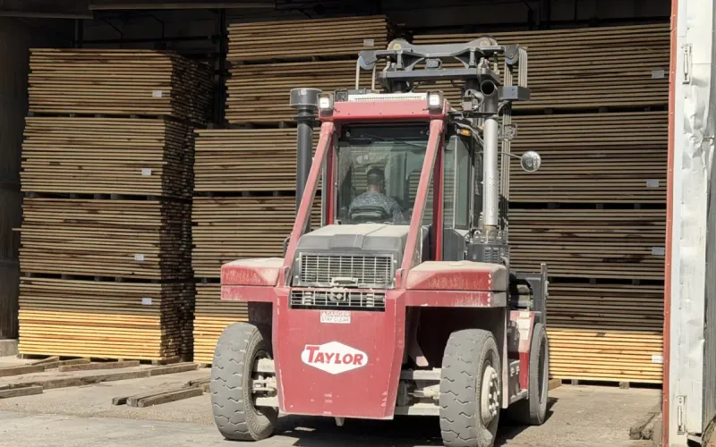 Tractor preparing woog rips to go into the drying kiln.